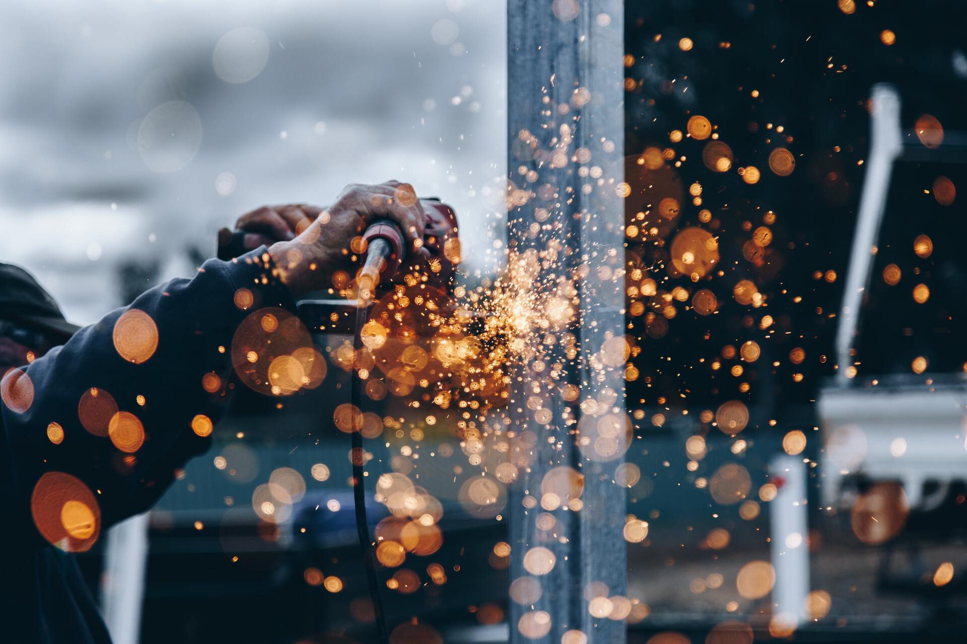 Artistic shot of a worker on a machine with sparks flying